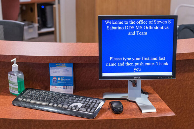 Check-in computer screen at SS Orthodontics showing welcome message for Steven S Sabatino Orthodontics in Glendale and Phoenix, AZ