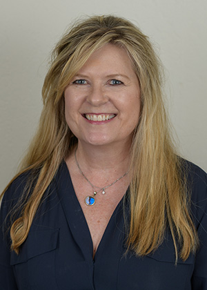 Staff photo of Patti with blonde hair in a navy blouse smiling at SS Orthodontics in Glendale and Phoenix, AZ