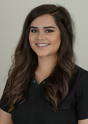 Staff photo of Savannah with long dark brown hair wearing a black top smiling at SS Orthodontics in Glendale and Phoenix, AZ