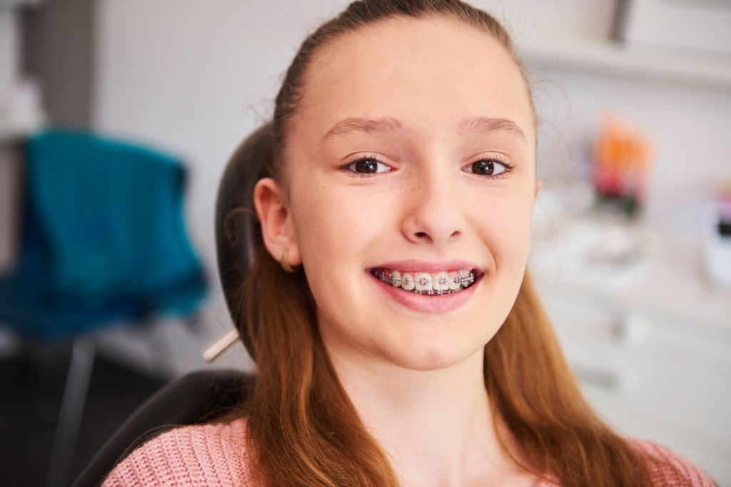 portrait-of-smiling-child-with-braces-in-dentist